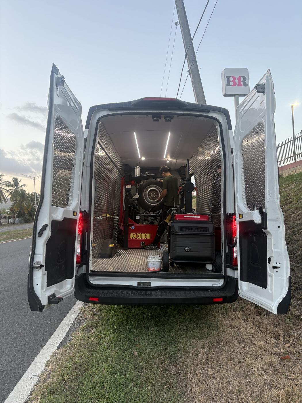 Guagua de RJ AutoXpress con las puertas traseras abiertas en servicio