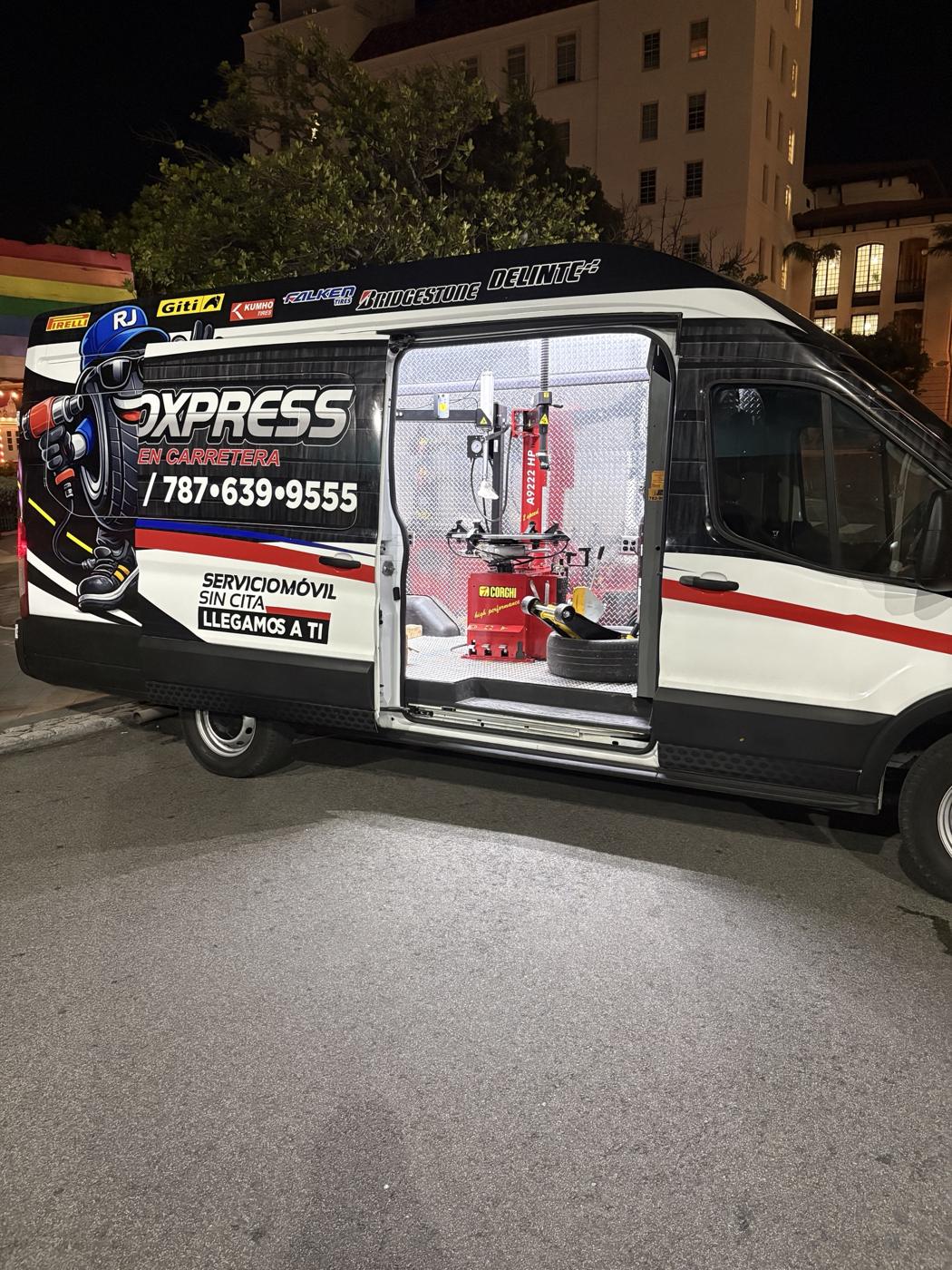 La guagua de RJ AutoXpress de noche con el taller encendido